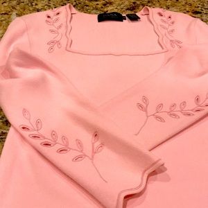 Knit top with florets around neckline and sleeves. New,never been worn.